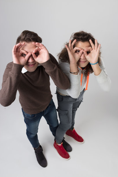 年轻人用手戴眼镜，穿着紧身牛仔裤，高跟运动鞋图片下载