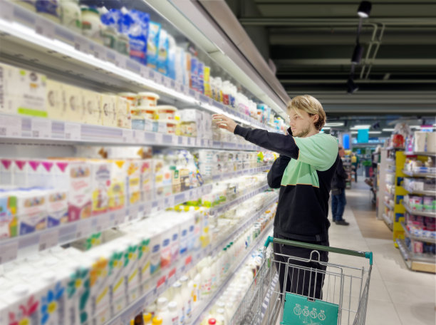 年轻人在超市购物，阅读产品信息图片下载