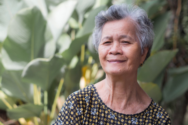 站在花园里，一头灰色短发的老妇人看着镜头。图片下载