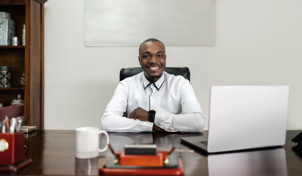 自信的非洲商人双手交叉坐在笔记本电脑上图片下载