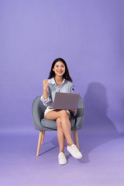 女孩坐在沙发上孤立的紫色背景的图像图片下载