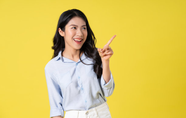 美丽的亚洲女孩在黄色背景上摆姿势的肖像图片下载