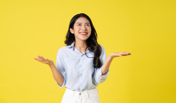 美丽的亚洲女孩在黄色背景上摆姿势的肖像图片下载