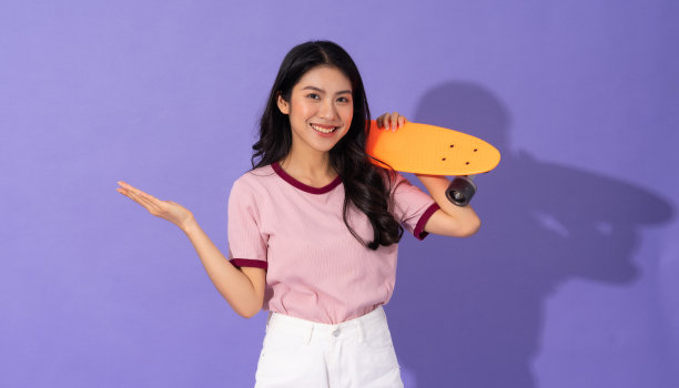 美丽的年轻女孩在紫色的背景图片下载