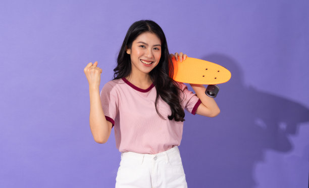 美丽的年轻女孩在紫色的背景图片下载