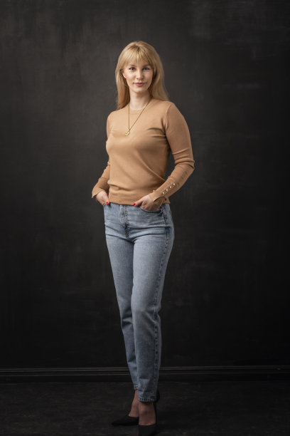 一个有吸引力的中年妇女在黑暗的背景下的全长图片下载