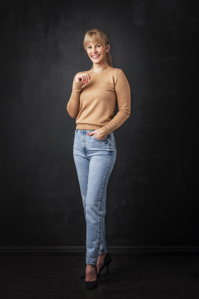 一个有吸引力的中年妇女在黑暗的背景下的全长图片下载