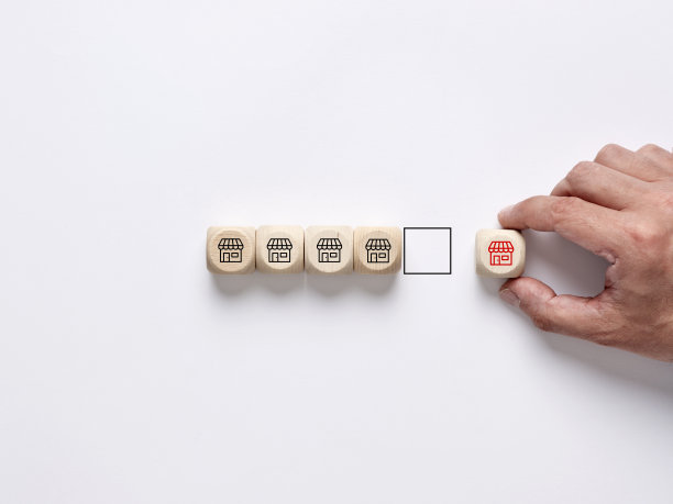 在特许经营链上增加一家新店。增加连锁店或增加一个新的销售点。特许经营管理。手工排列带有商店符号的木块。图片下载