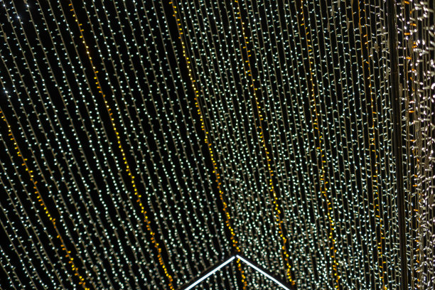 抽象的灯。圣诞街灯呈直线形，不对焦。白色和金色的灯。黑色背景。西班牙加那利群岛的特内里费岛。图片下载