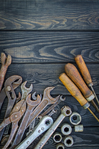 生锈的旧工具在黑色的复古木材背景。图片下载