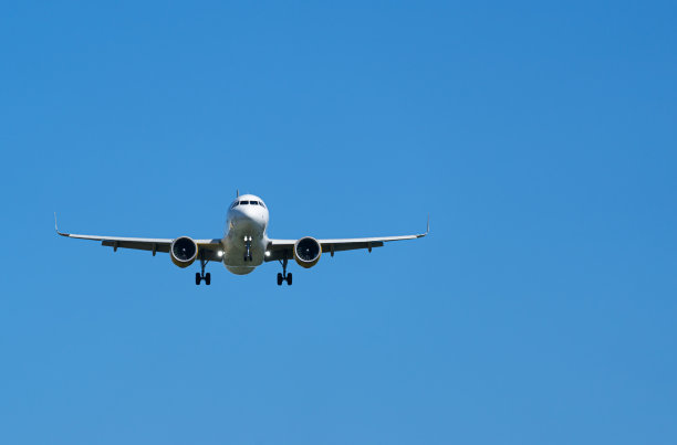 在蓝天下降落的飞机的低角度视图图片下载