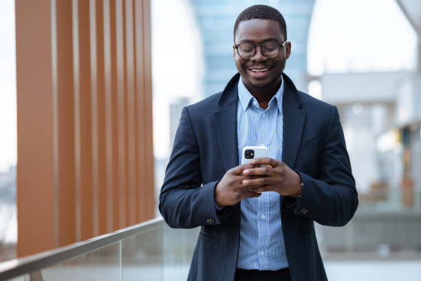 优雅的非裔美国年轻人在城市使用智能手机图片下载
