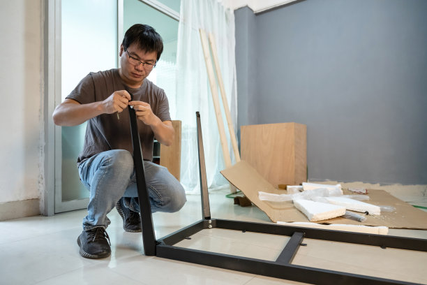 一个男人正在房间里安装家具图片下载