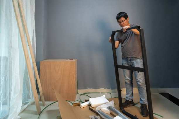 一位中年男子正在他的工作室里安装家具图片下载