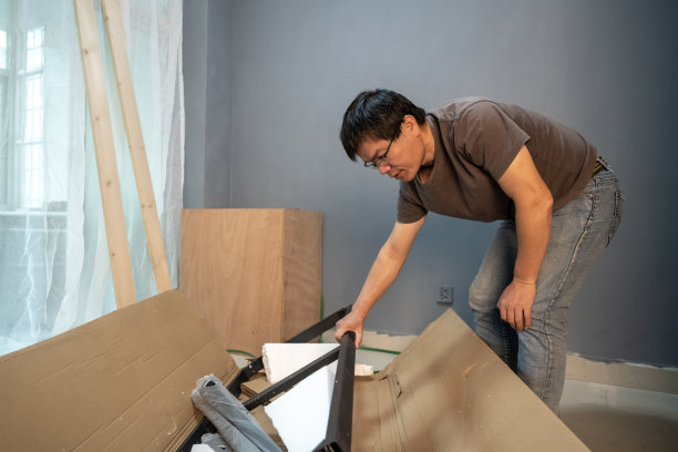 一位中年男子正在他的工作室里安装家具图片下载