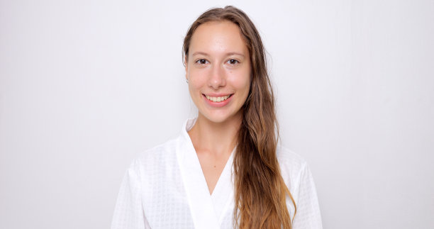 画像的年轻女子长头发在白色浴袍微笑图片下载