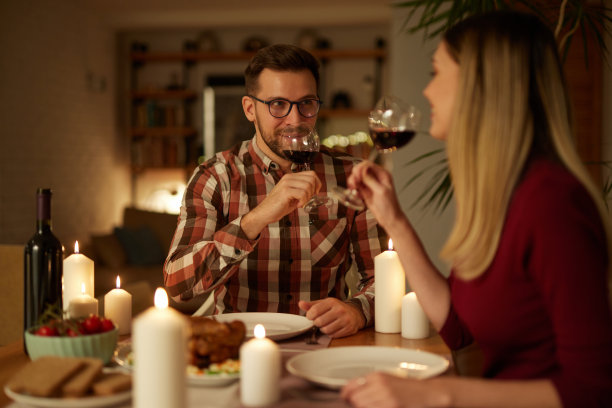 美丽的情侣在家里用蜡烛和红酒共进浪漫的晚餐图片下载