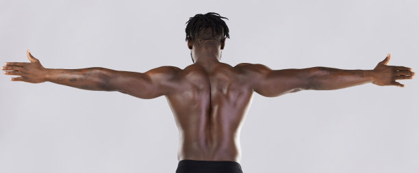 背部，手臂和肌肉与一个模型黑人男子摆姿势在工作室的灰色背景健身或锻炼。肌肉，健康和健康与强壮的男性运动员站立或弯曲的力量图片下载