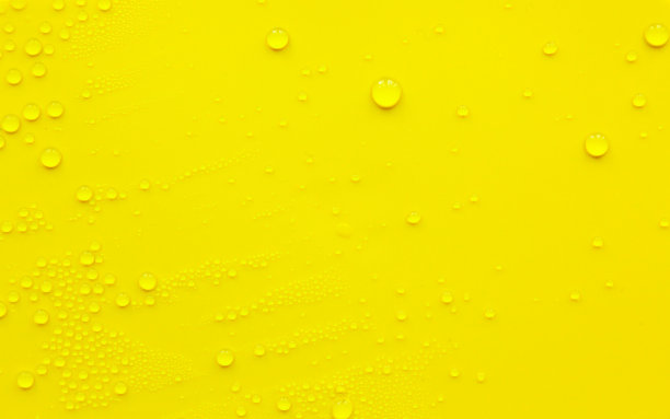 水滴在黄色的背景上。图片下载