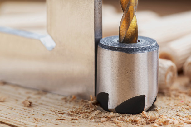 沉孔钻头用钢三角尺在橡木木板上钻螺丝孔图片下载