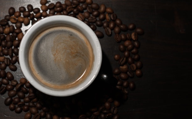 咖啡杯与豆子在复古桌上图片下载