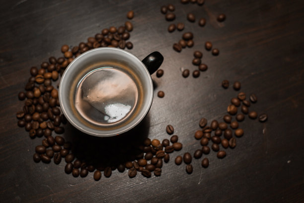 咖啡杯与豆子在复古桌上图片下载