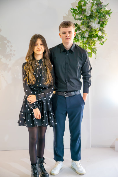 十几岁的男孩和女孩穿着深色衣服，背景很浅。图片下载