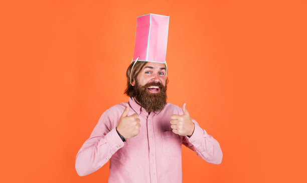 商场大减价。商人拿着礼物包。送给同事的礼物。惊讶的男人打开行李。包裹递送。人类的情感和面部表情。男人礼物节日装饰图片下载