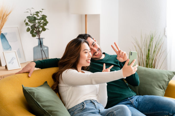 幸福的情侣用智能手机自拍图片下载