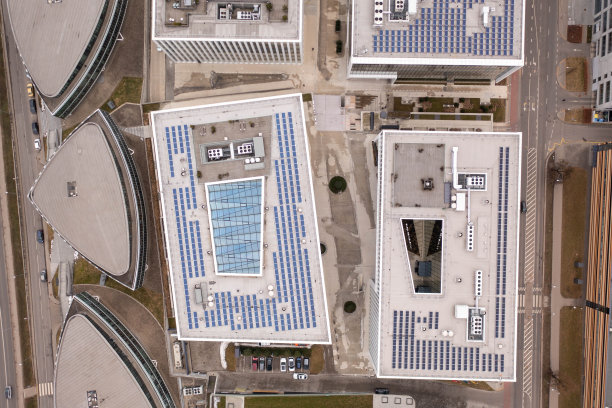 在多云的春天，无人机拍摄办公室屋顶和太阳能电池板。图片下载