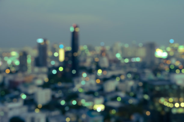 模糊的暮色中，城市办公楼的灯光，抽象的背景图片下载