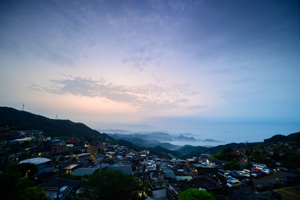 令人惊叹的黄昏风景-充满活力的橙色天空，动态的云，雾蒙蒙的山。图片下载