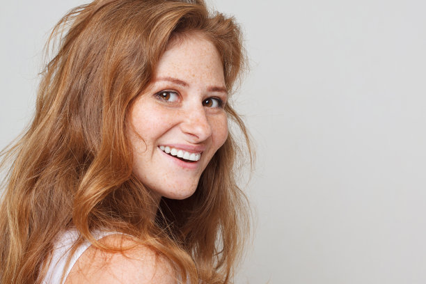 女性的美。年轻美丽的红发女子在白色背景上对相机微笑的特写图片下载