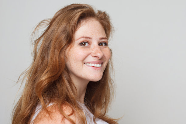 女人肖像。美丽的女模特女士与雀斑和长姜发型看着相机在白色背景图片下载