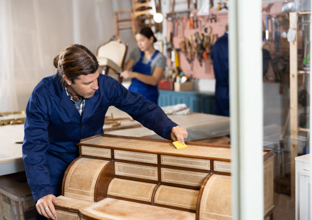 经验丰富的修复师在修复车间小心翼翼地修复抽屉柜图片下载