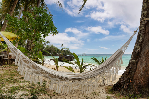 热带海湾海滩上的棉质吊床图片下载