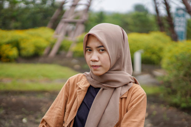 近距离拍摄的亚洲穆斯林妇女戴着头巾坐在公园的长椅上图片下载