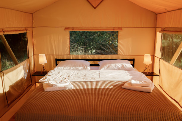 舒适的开放式豪华野营帐篷内部，在日落时有灯光。户外避暑度假豪华露营帐篷。生活方式的概念图片下载