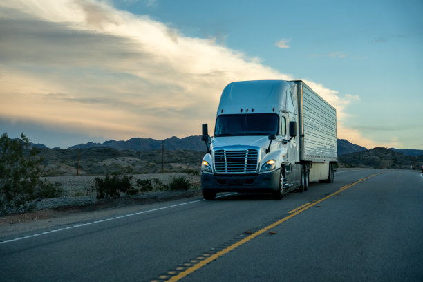 两车道高速公路上的半卡车，天空中有美丽的云图片下载