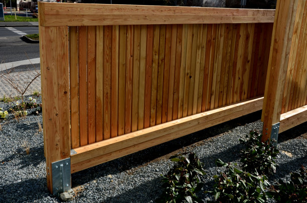 豪华的栅栏结合了由草制成的黑色金属杆垂直折叠成一个拱门。木材位于金属条之间，形成了坚固的不透明墙壁。花园有隐私图片下载