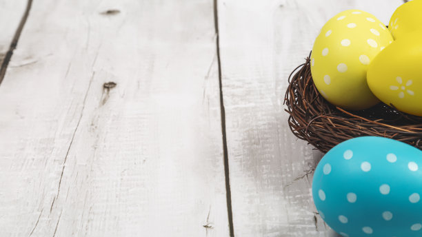 五颜六色的复活节彩蛋在鸟巢上的木制背景。复活节假期概念。本空间图片下载