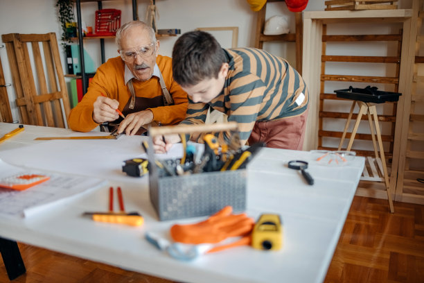 男孩在祖父的木工作坊帮忙图片下载