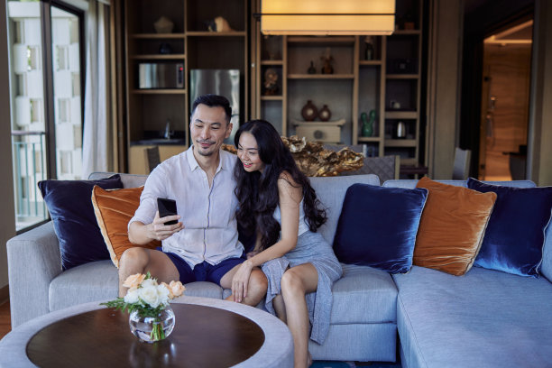 丈夫和妻子坐在沙发上自拍。快乐的亚洲夫妇在家里的客厅玩得很开心图片下载