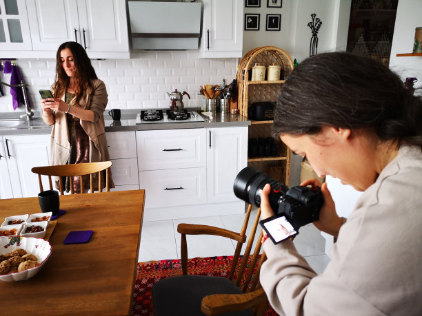 一个摄影师在厨房里给一个女人照相图片下载