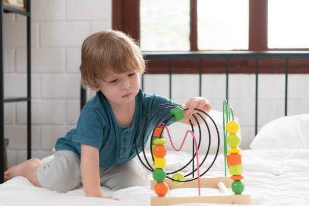 小男孩在他的卧室里拿着一个新玩具图片下载