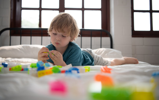 小男孩在他的卧室里拿着一个新玩具图片下载