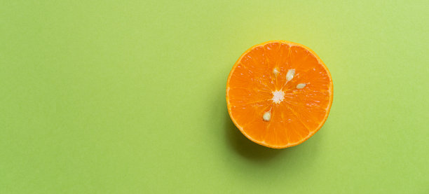 在绿色背景上切橘子图片下载