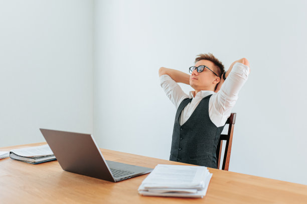 一位上班族靠在椅子上，闭着眼睛享受着片刻的放松图片下载