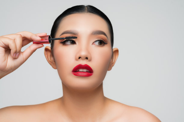 手持睫毛膏的美丽亚洲女子肖像图片下载