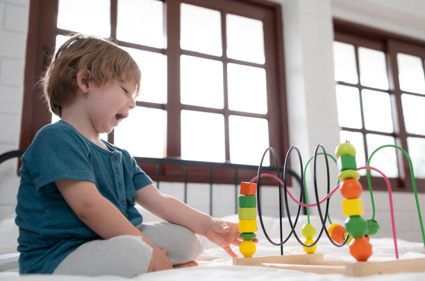 小男孩在他的卧室里，拿着他父母买的新玩具，帮助他提高思考能力。图片下载